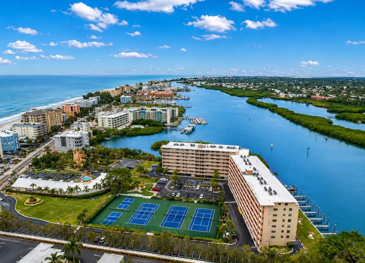 Aerial over the club showing the lighted courts, the building and the docks on the Intracoastal